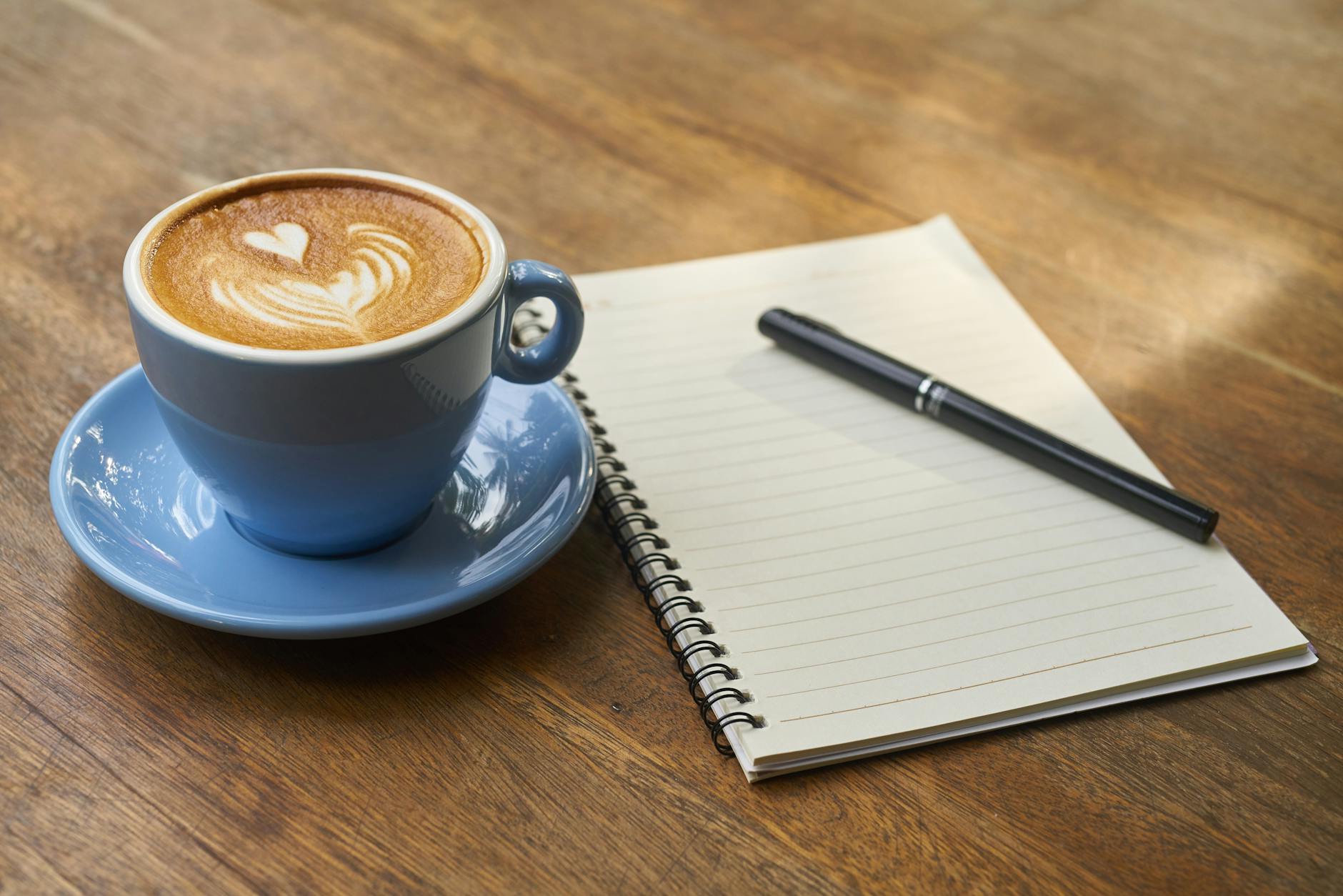 coffee on saucer beside the notebook